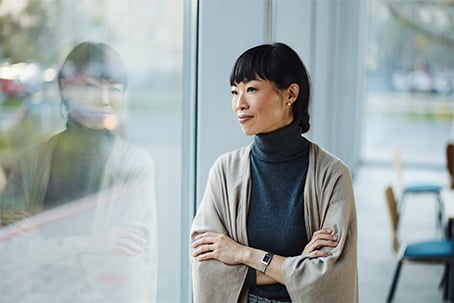Woman looking through the window reflecting